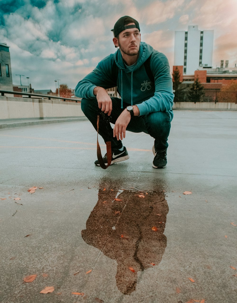 man wearing blue hoodie docking on rooftop of the building