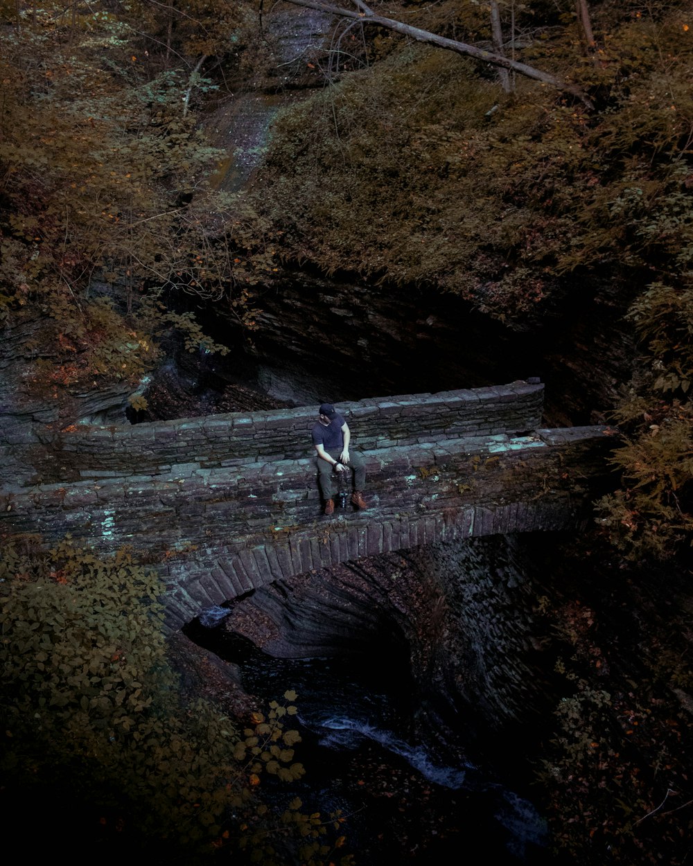 homme assis sur un pont en béton gris