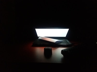 photo of turned on laptop computer on brown table