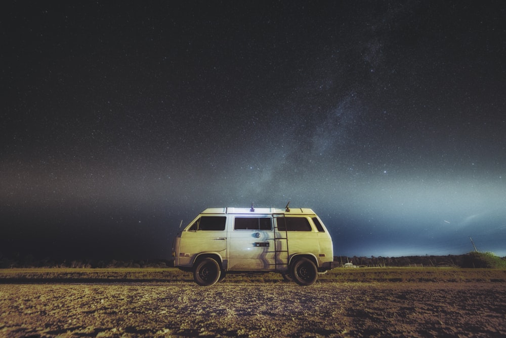 furgone bianco e marrone parcheggiato sotto la vista della Via Lattea