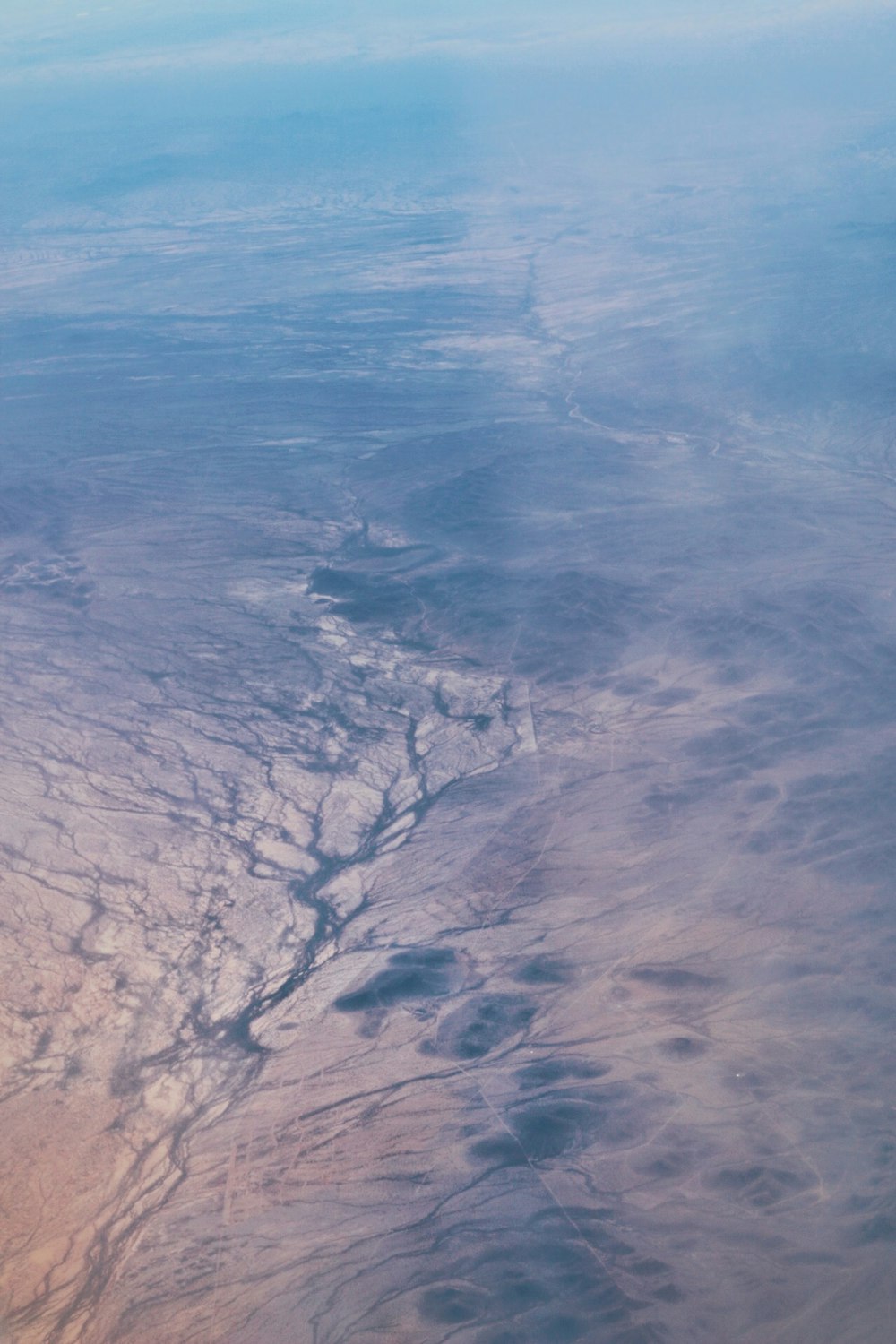 aerial photography of land with lake under white cloud blue skies