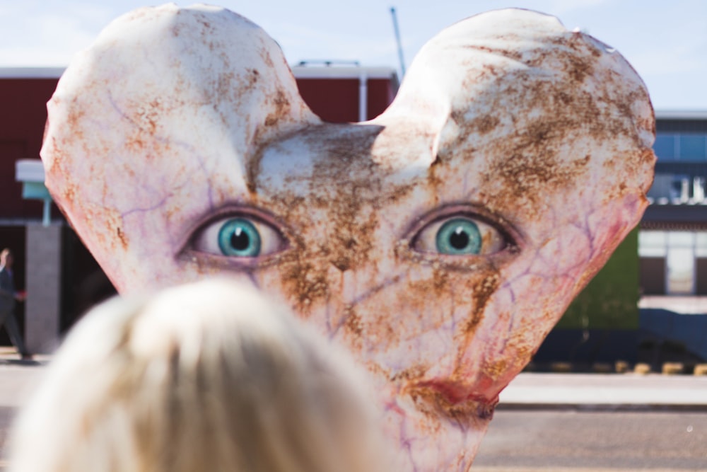 concrete statue with eyes near building