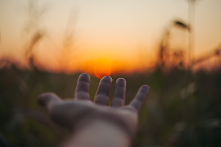 Hand touching healing from morning sun rays.  