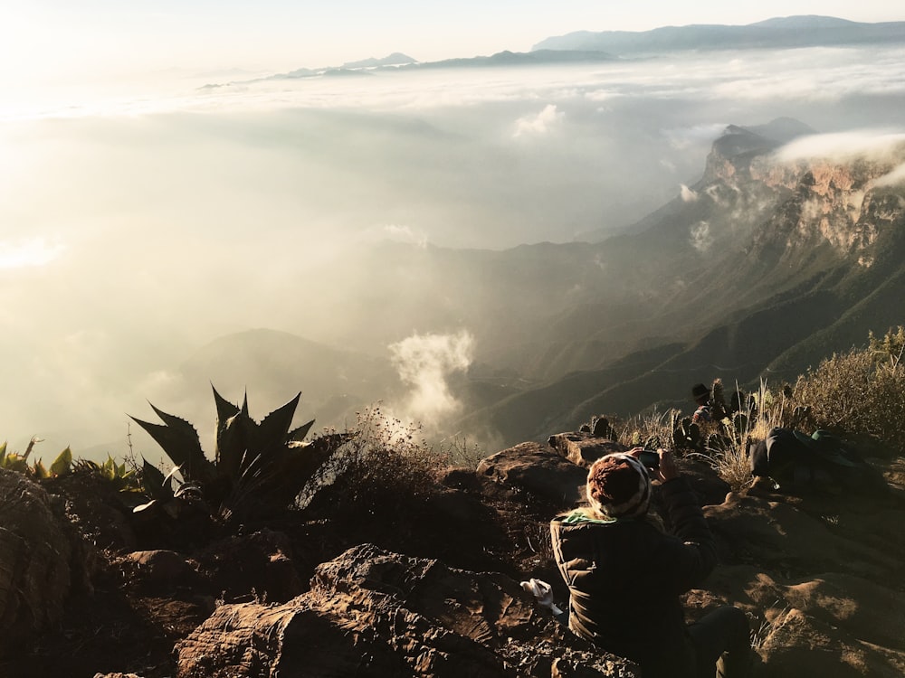 person sitting on cliff