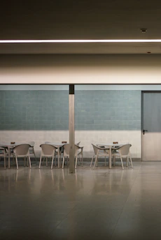 Wide shot of a minimalist event backdrop with clean lines and subtle golden accents in a spacious room.