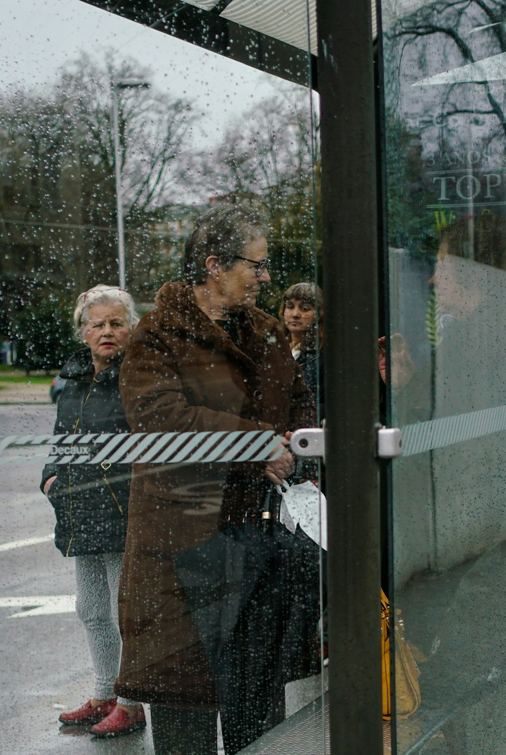 Person mit Regenschirm in der Nähe von Glastür