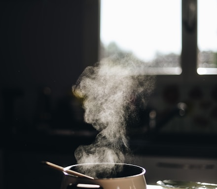 white casserole with gray spoon on black surface