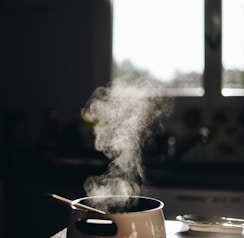 white casserole with gray spoon on black surface