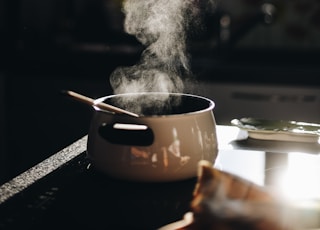 white casserole with gray spoon on black surface