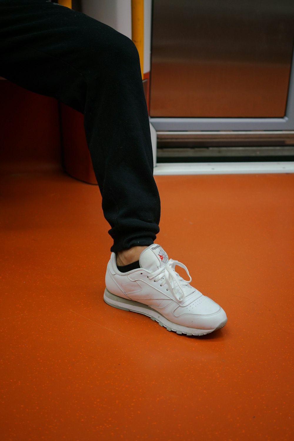 a person standing on a train with their foot on the ground