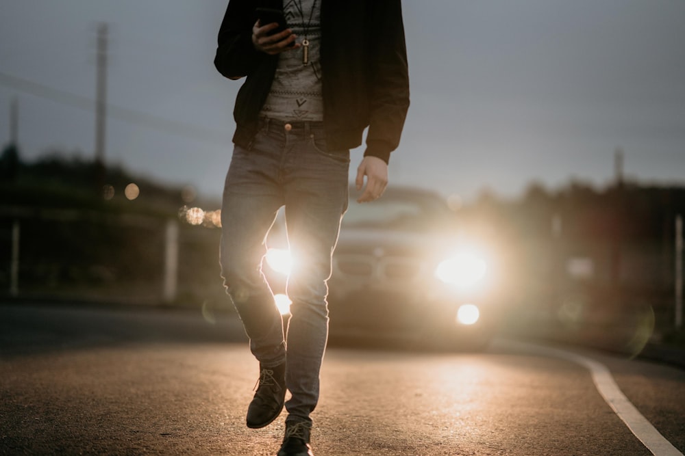 homem na jaqueta preta andando na rua