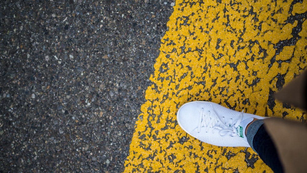 persona con zapato adidas Stan Smith blanco