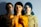 Three overlapping images of the same person with different lighting and colors. The leftmost figure is dimly lit, the middle figure is bathed in warm light with floral texture, and the rightmost figure wears a sunflower-patterned shirt.