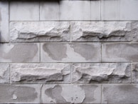 Rough-cut limestone blocks showing natural textures and earthy tones outdoors.