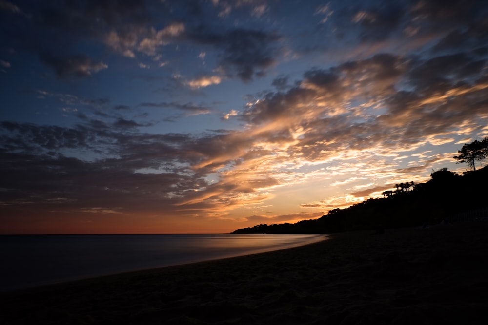 Plage de silhouette au coucher du soleil