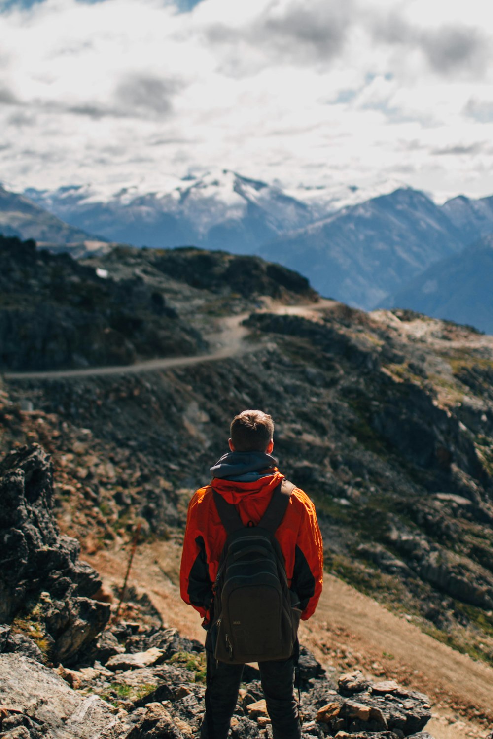 man standing on rock formation mountain at daytime