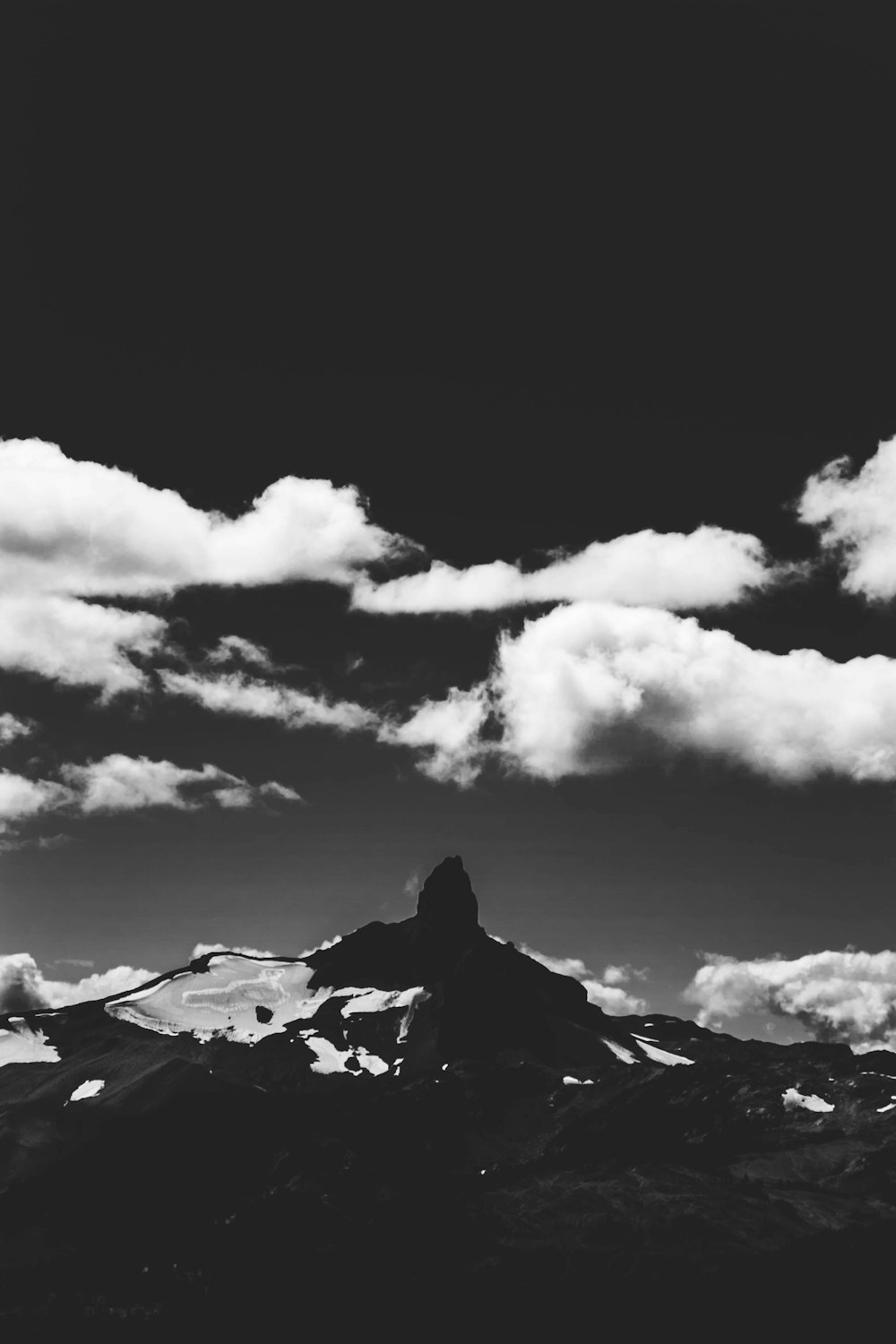 grayscale photography of mountain and clouds