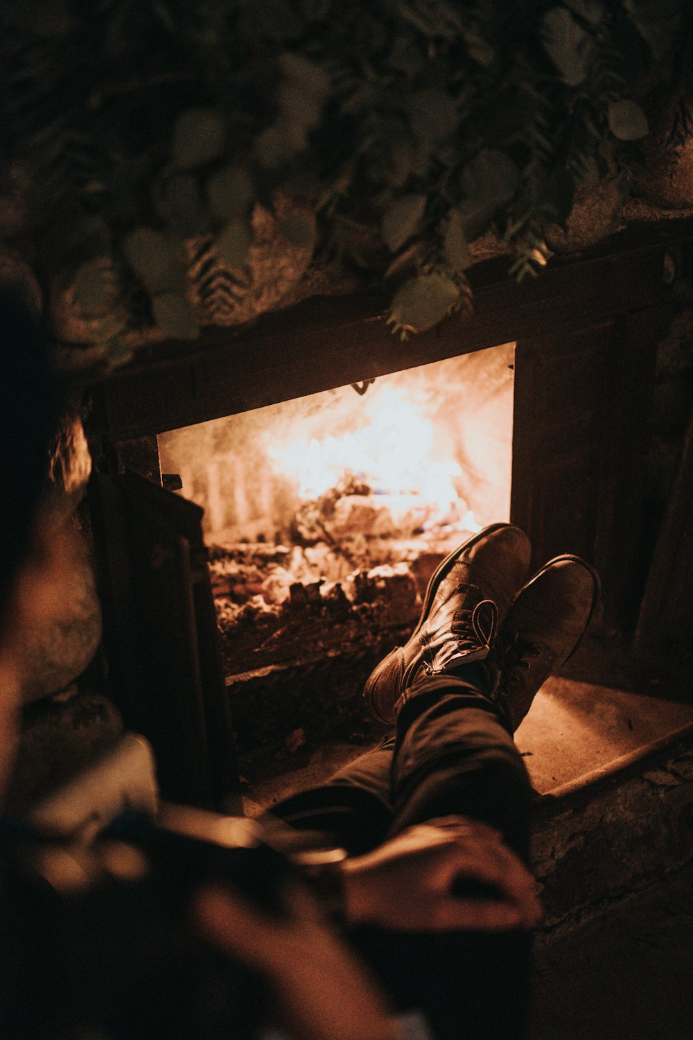 Mann sitzt vor dem Kamin