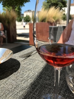 Close-up of a chilled glass of rosé wine beside a plate of fresh Mediterranean tapas on a weathered stone table.