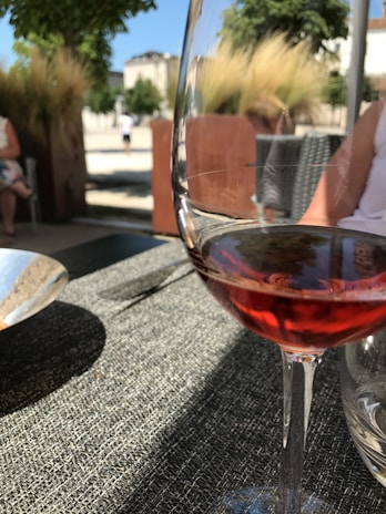 Close-up of a chilled glass of rosé wine beside a plate of fresh Mediterranean tapas on a weathered stone table.