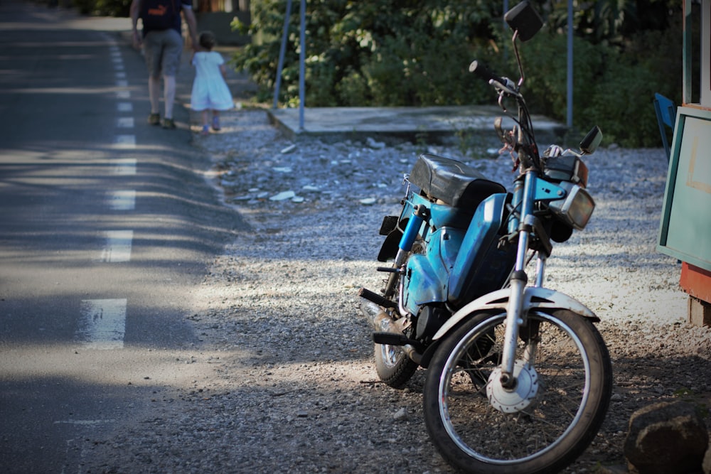 blue moped motorcycle near road