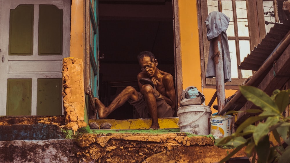 man sitting on door frame