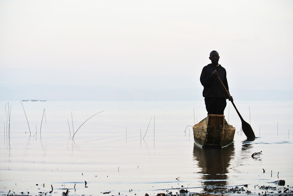 man riding brown canoe