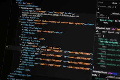 A close-up of a computer screen displays lines of HTML and CSS code. The code includes elements such as a navigation bar, container, and various task items with unique IDs. The screen also shows a styles section with properties like margin and padding.