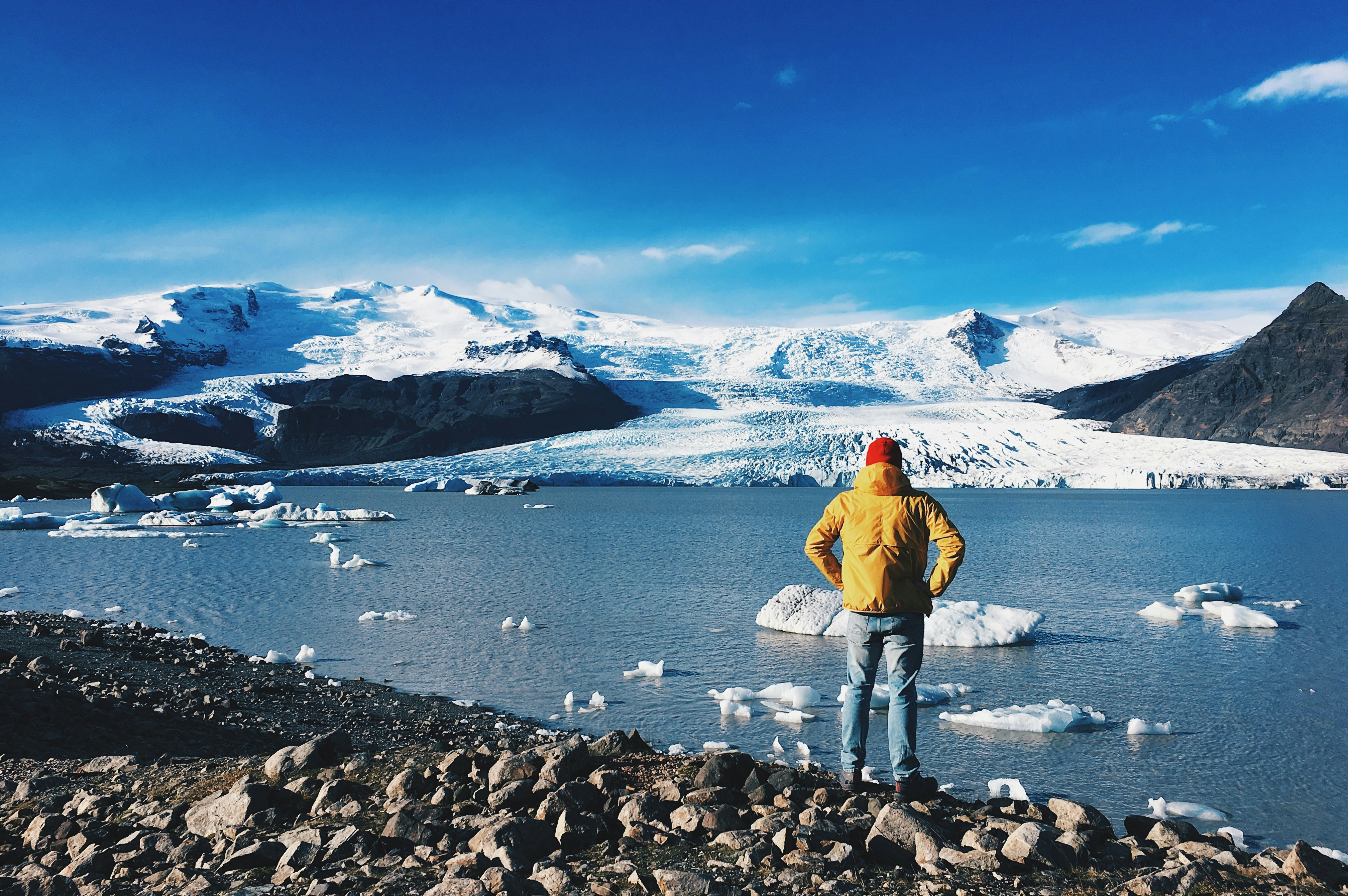 man standing in front of ice lake, 