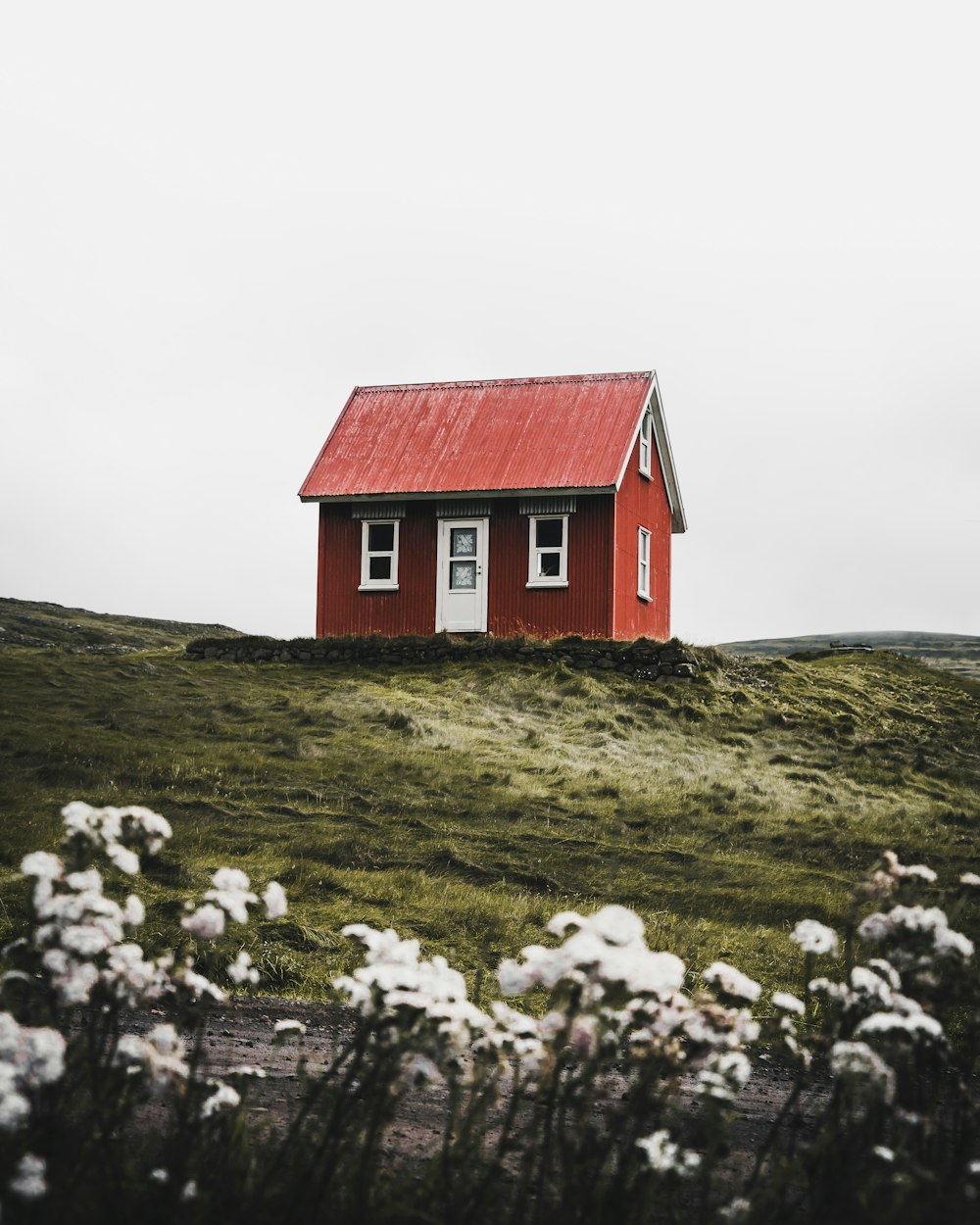 赤と白の家が緑の芝生を囲む