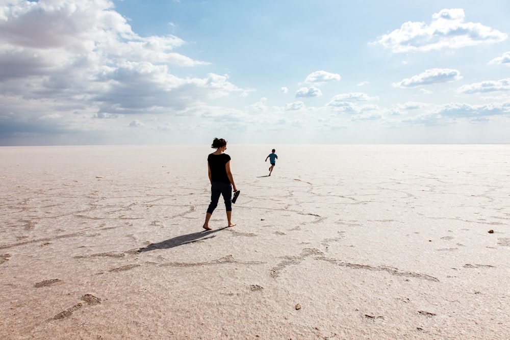 Mulher e menino caminhando em local deserto