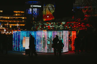 A lively family enjoying a colorful mall event with lights and interactive installations.