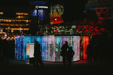 A lively family enjoying a colorful mall event with lights and interactive installations.