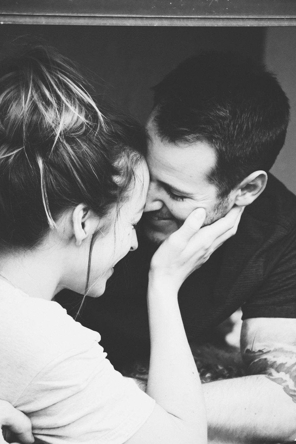 grayscale photography of woman holding man's face