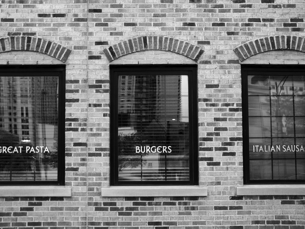 Fotografía en escala de grises de un edificio con ventanas de vidrio
