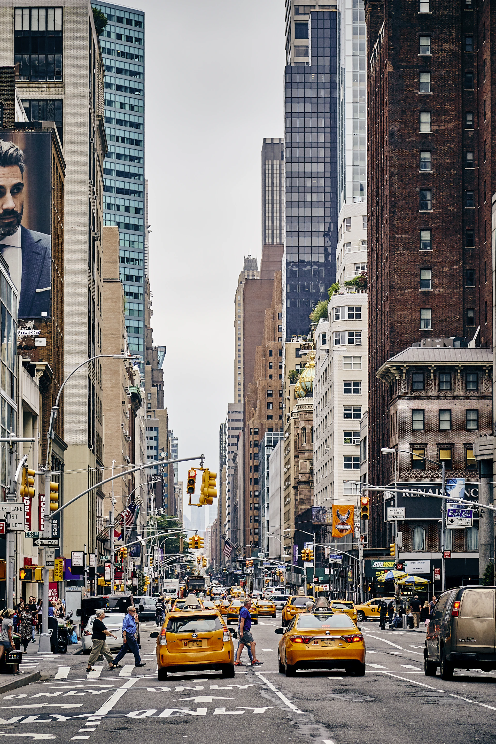 Yellow taxis lining a Manhattan avenue between towering skyscrapers