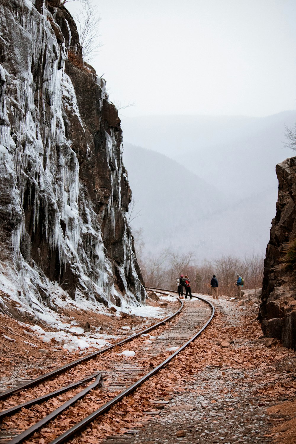 four men standing on train railway