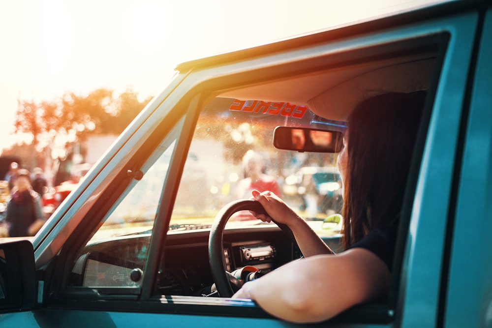 Frau mit Lenkrad sitzt im Auto