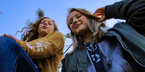 two women posing and looking down at the camera