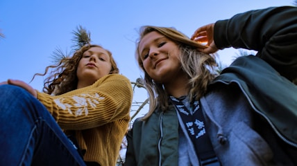 two women posing and looking down at the camera