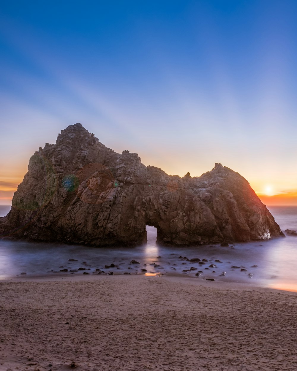 photography of rock formation on body of water