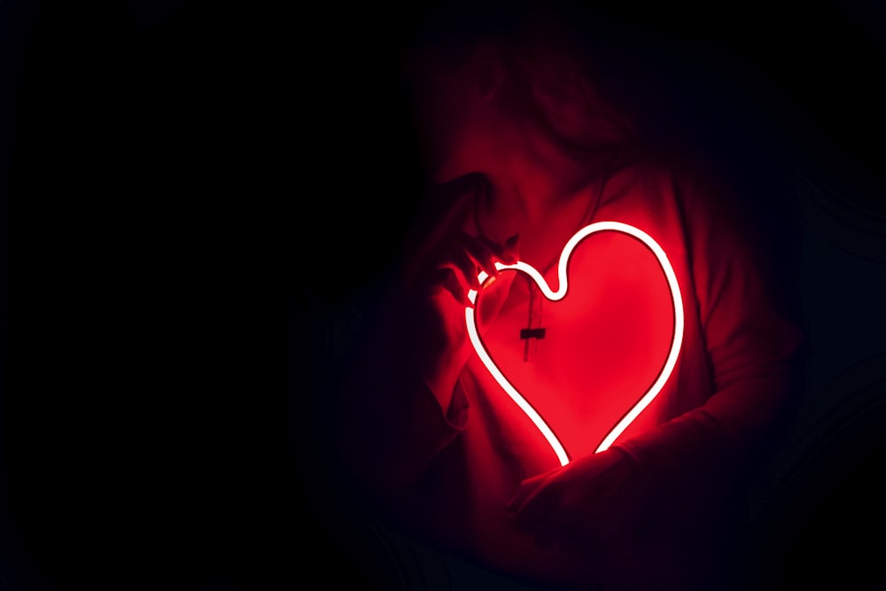 a heart shaped neon sign in the dark