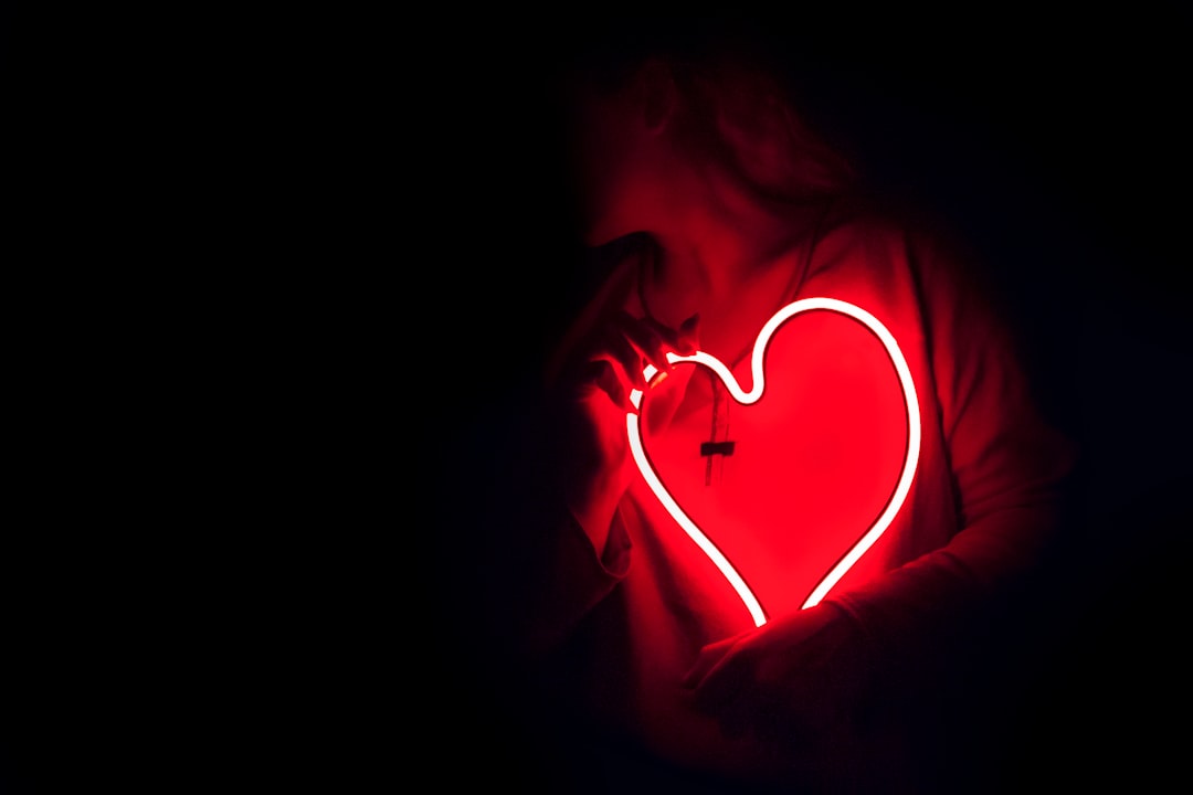 a heart shaped neon sign in the dark