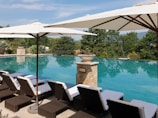 Luxurious infinity pool with sun loungers and soft golden lighting