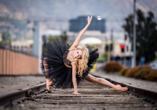 woman in black tutu dress posing on railway