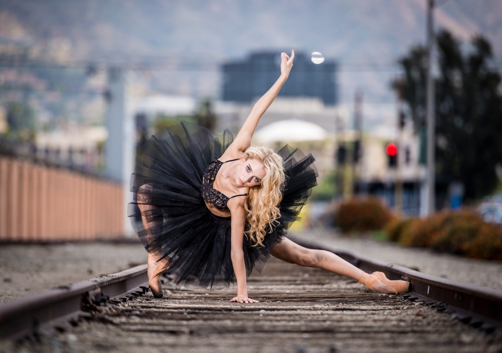 woman in black tutu dress posing on railway