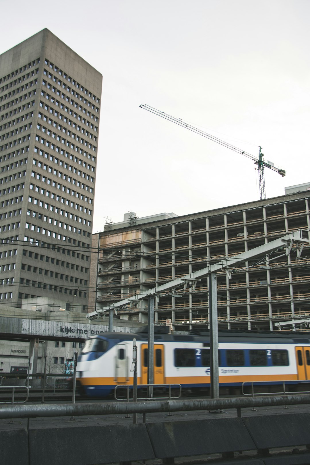 photo of white and brown train near concrete buildings during daytime