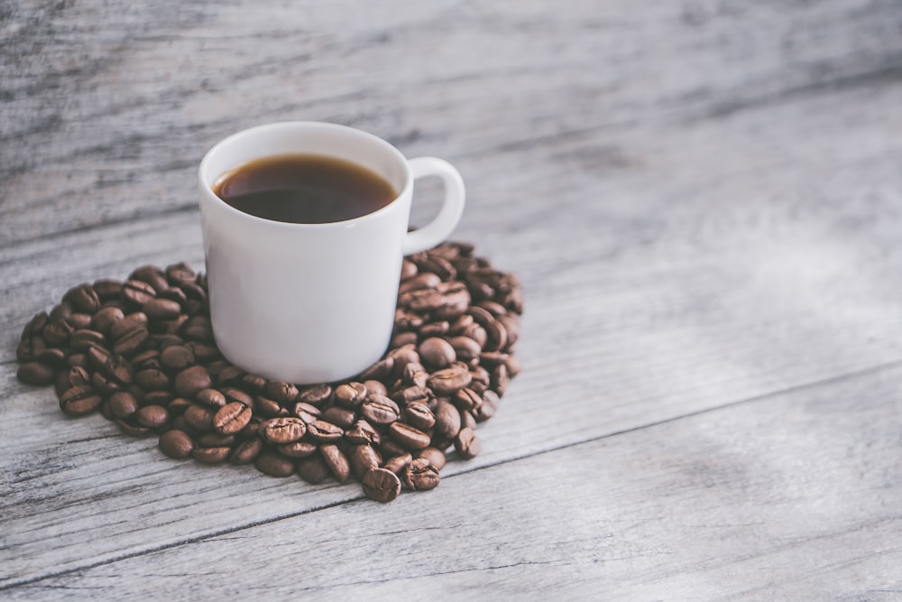 cup of coffee on coffee beans