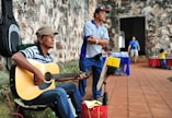 man playing cutaway acoustic guitar