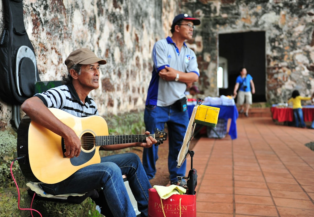 man playing cutaway acoustic guitar